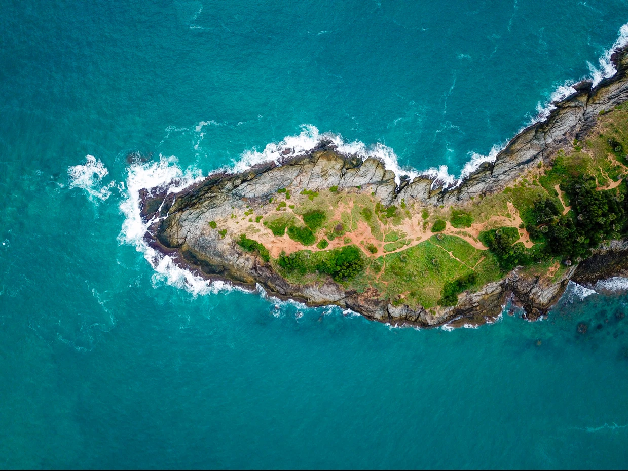 Aerial View of Promthep Cape in Phuket overlooking the rocky shore and turquoise sea