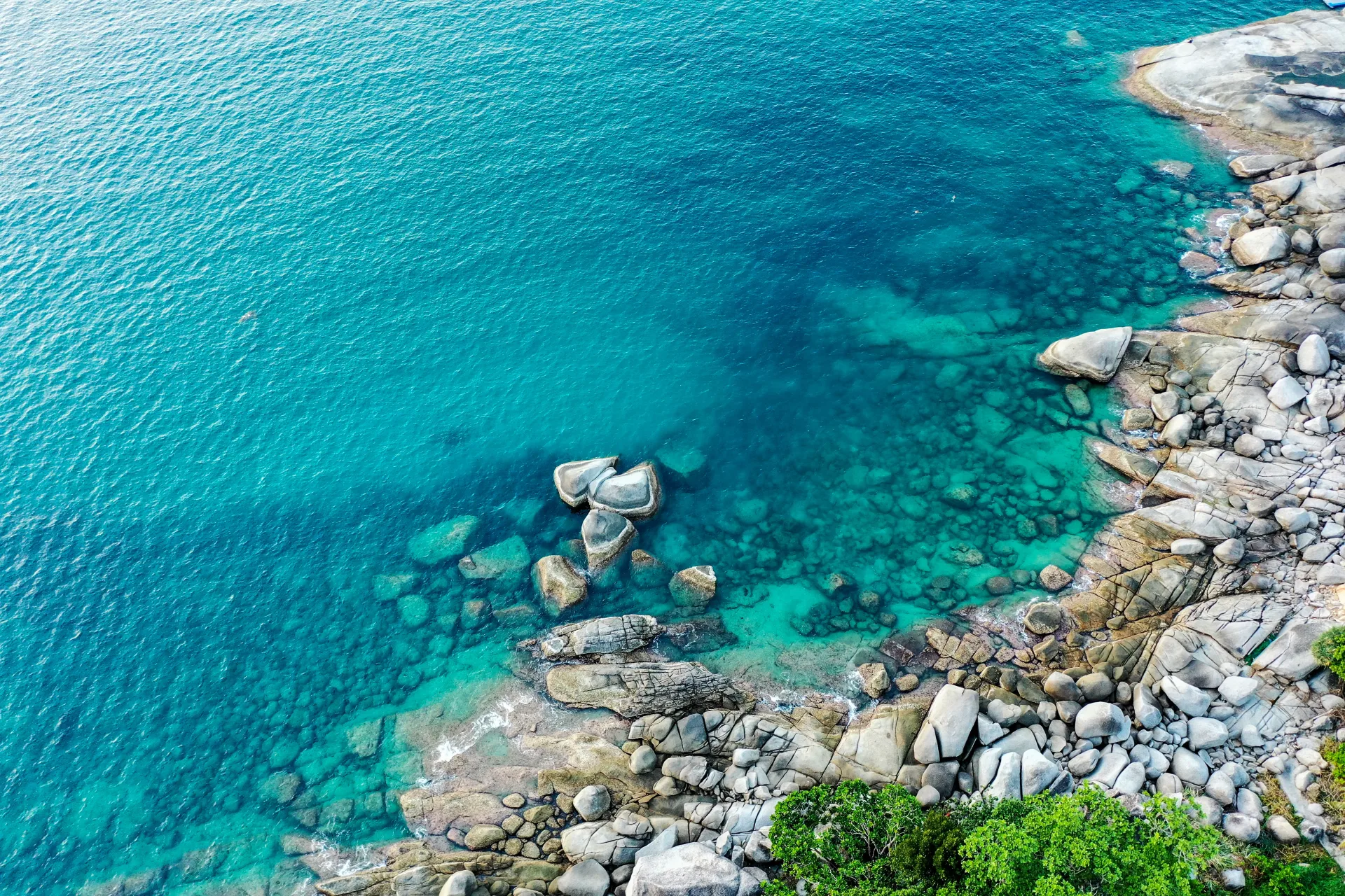 Top view of crystal clear turquoise water and picturesque rocks off the coast of Phuket with the inscription 'Phuket'