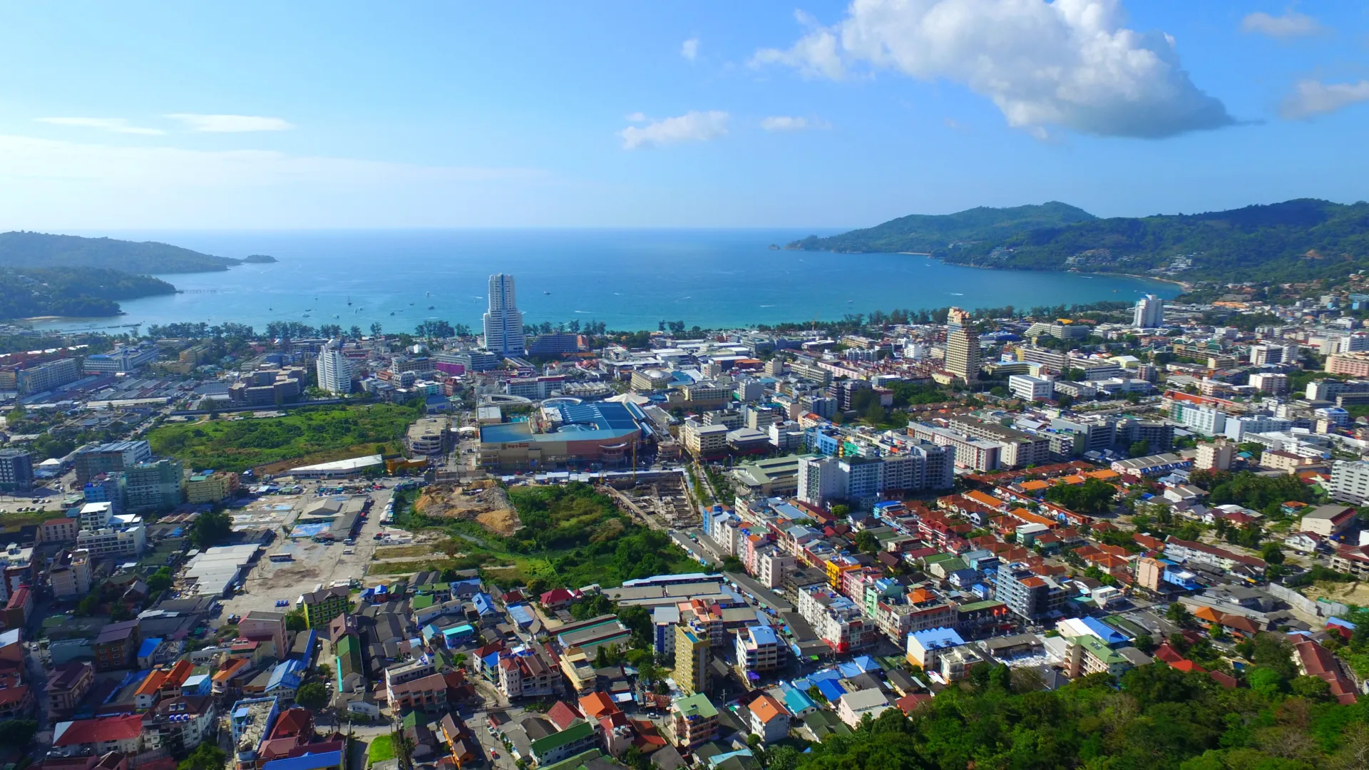 Panoramic overview of Patong Phuket: sea, mountains, and city architecture during the day