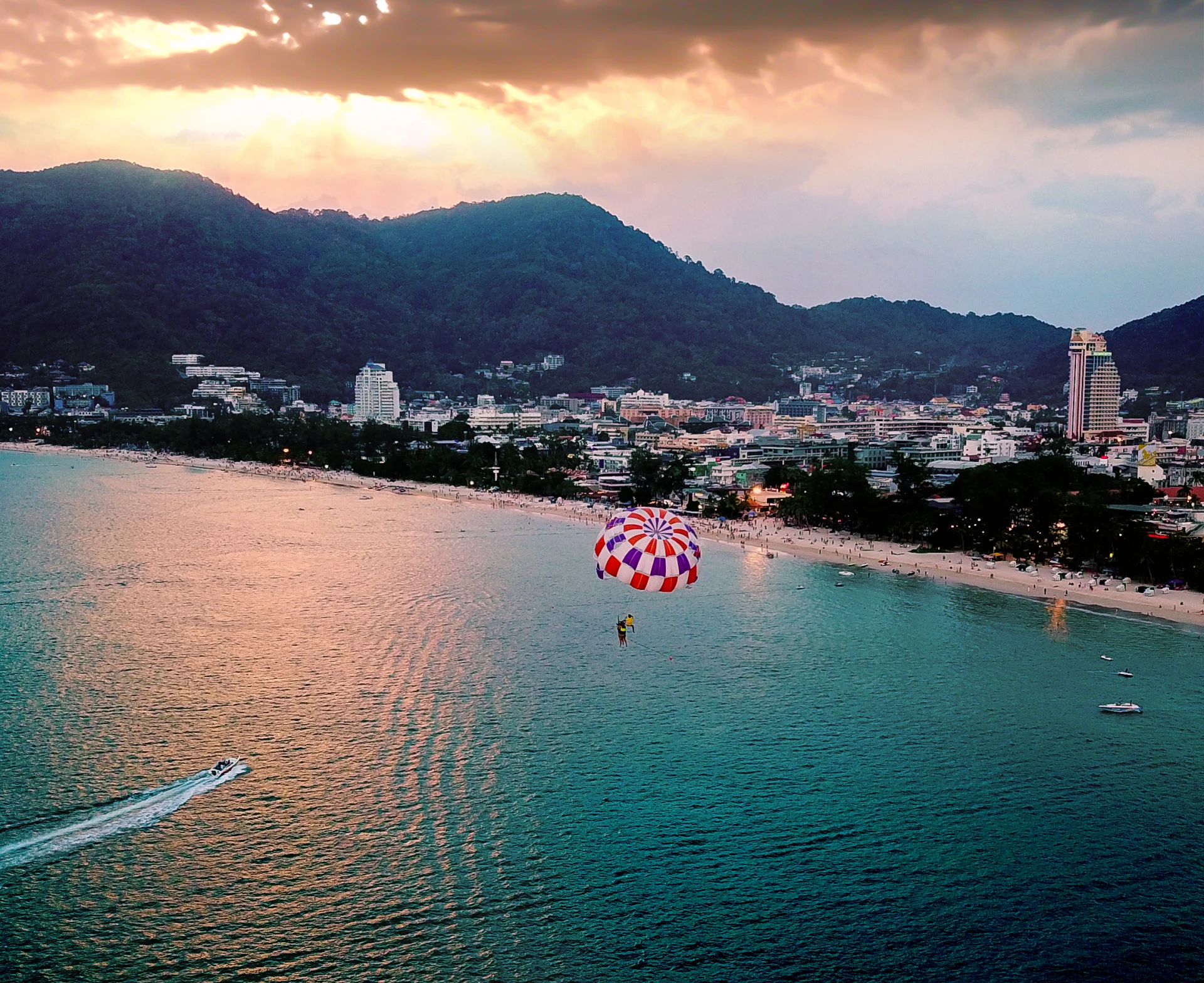 Active recreation in Phuket: parasailing at Patong Beach, evening view of the coastline