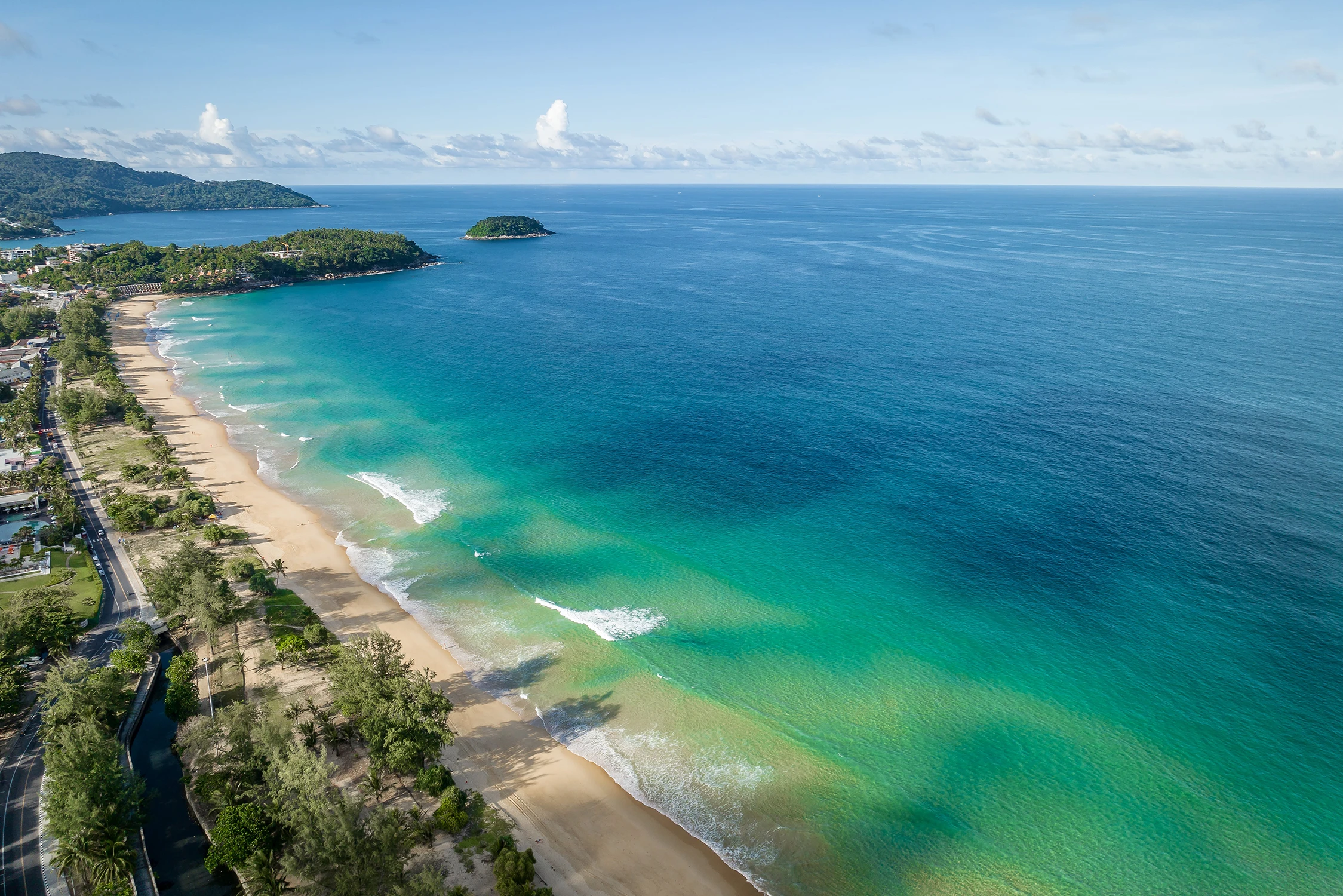Aerial photography of Karon beach overlooking the Andaman Sea and a small island on the horizon