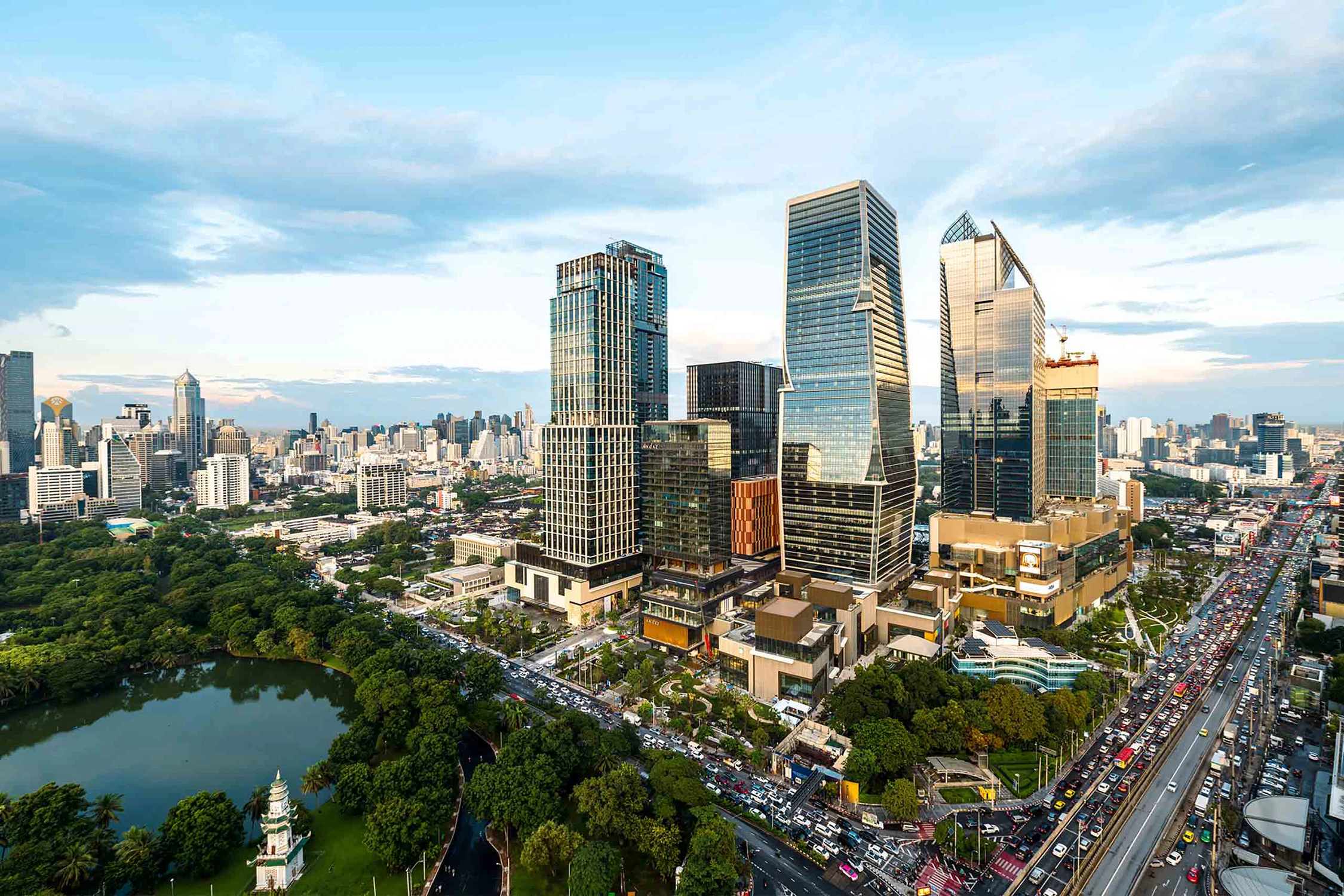 曼谷隆比尼公园和繁忙公路旁的现代玻璃办公楼及住宅综合体